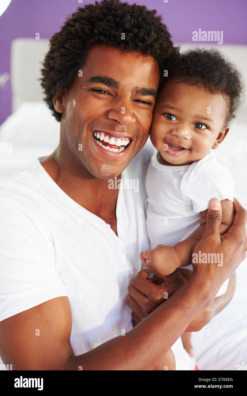 Dad Cuddling Baby Son At Home Stock Photo