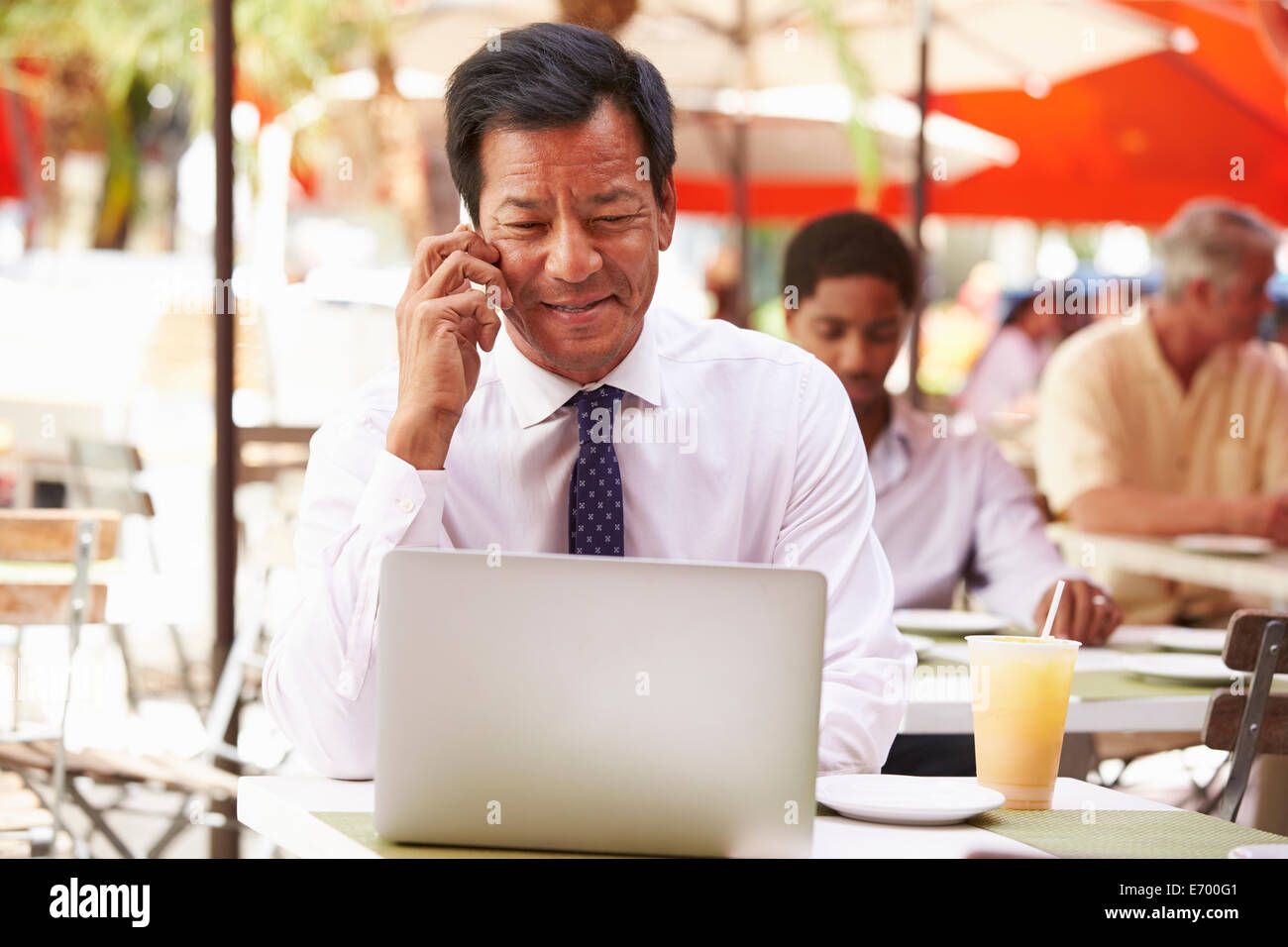 Businessman Working On Laptop In Outdoor Café Stock Photo