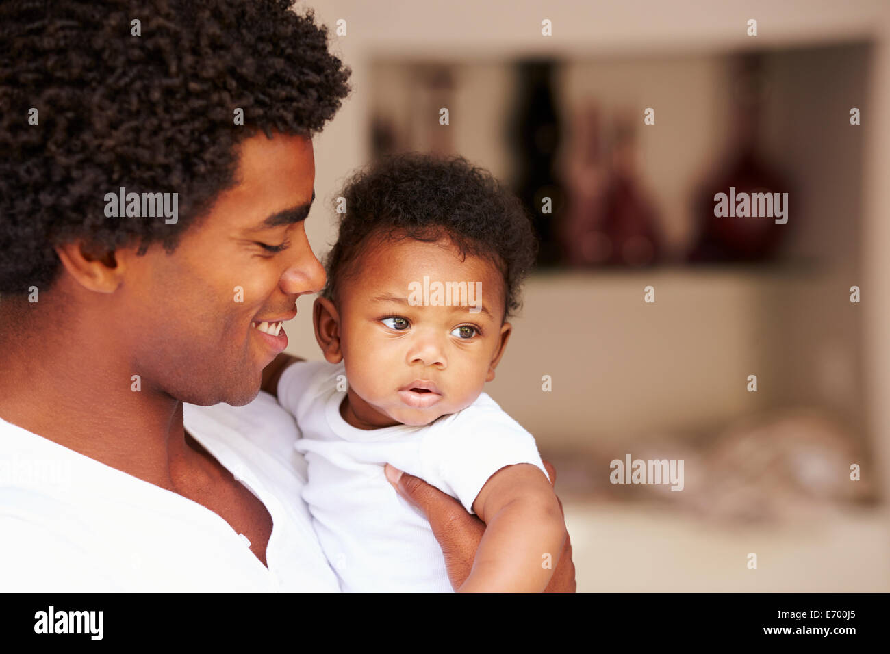 Dad Cuddling Baby Son At Home Stock Photo