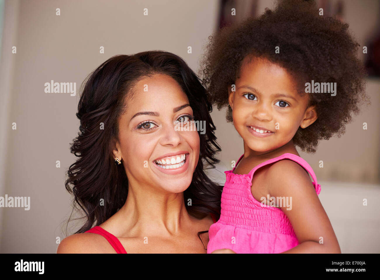 Mother Cuddling Daughter At Home Stock Photo
