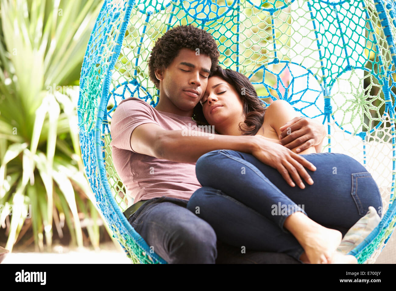 Couple Relaxing On Outdoor Garden Swing Seat Stock Photo