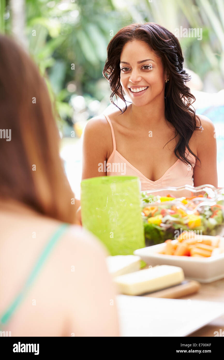 Two Female Friends Enjoying Meal Outdoors At Home Stock Photo