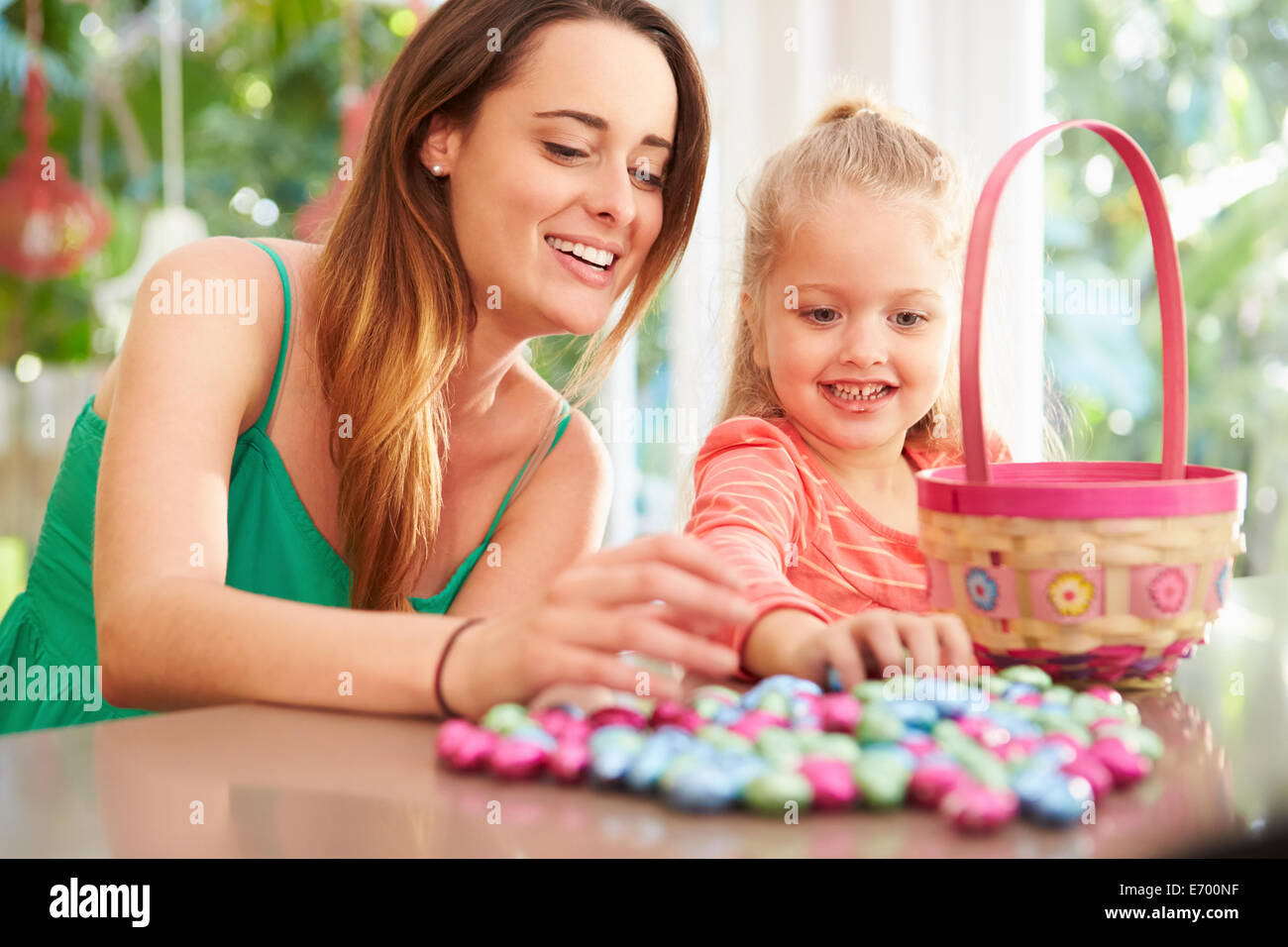 Mother And Daughter With Chocolate Easter Eggs And Basket Stock Photo