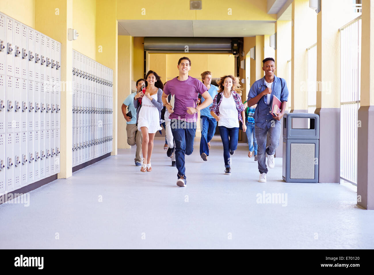 Group Of High School Students Running In Corridor Stock Photo