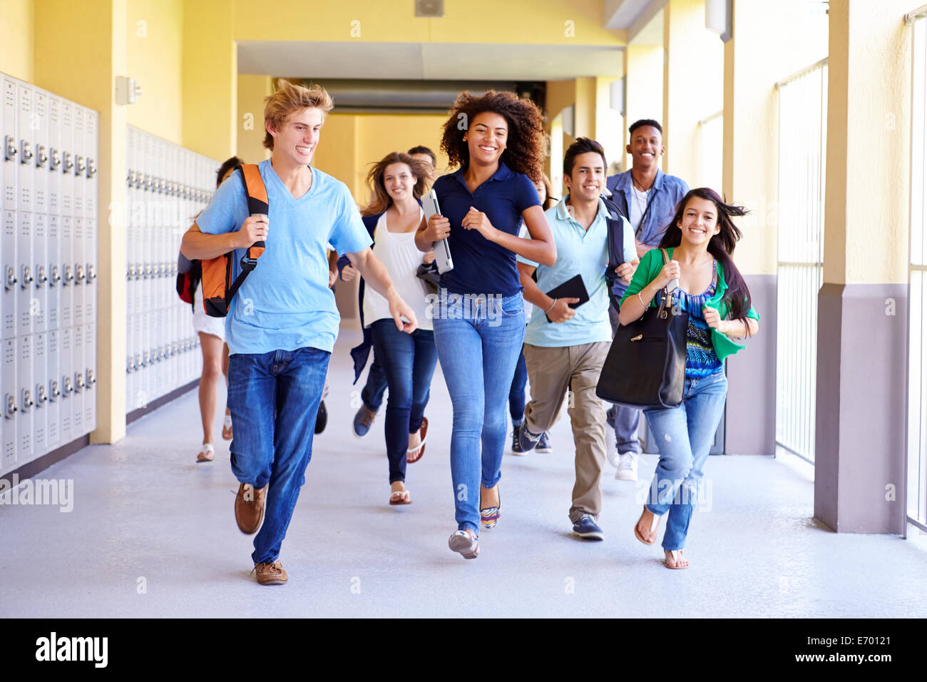 Group Of High School Students Running In Corridor Stock Photo