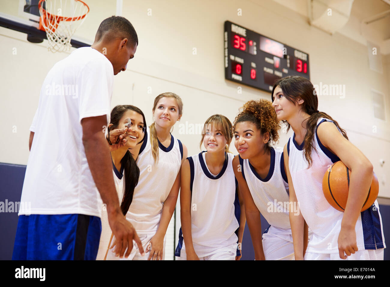 High School Basketball Team Having Team Talk With Coach Stock Photo