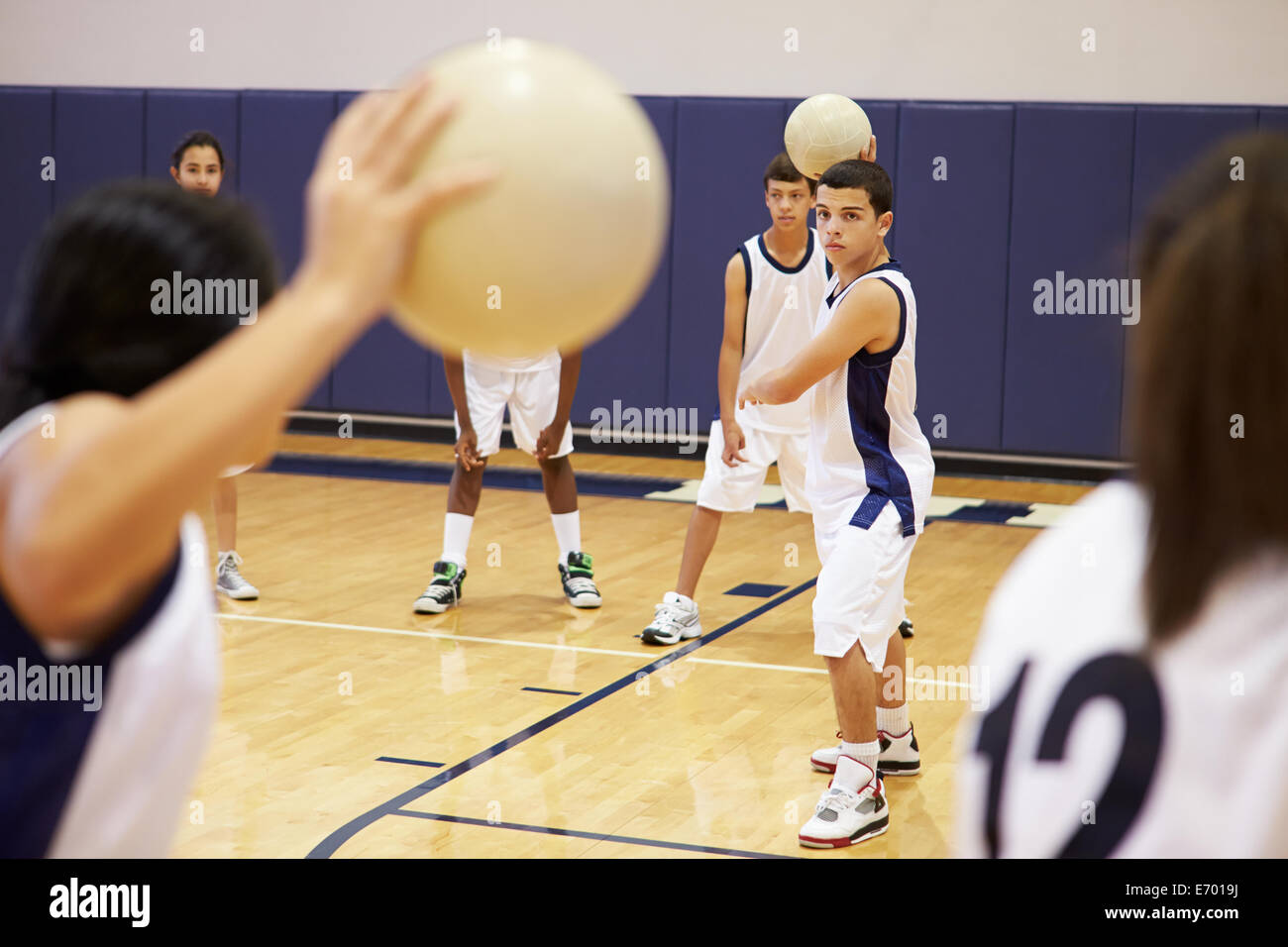 High School Students Playing Dodge Ball In Gym Stock Photo