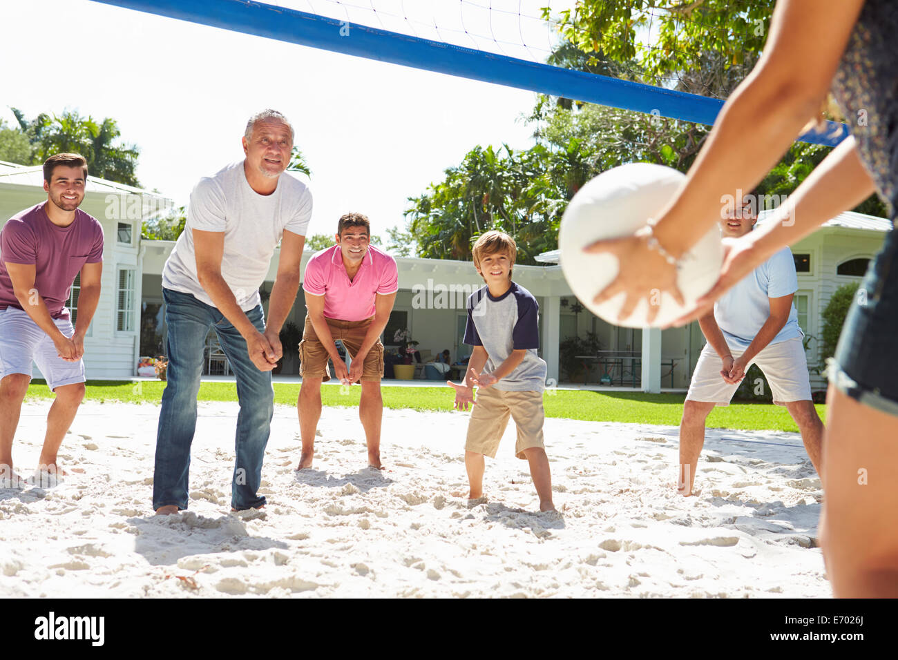 Male Multi Generation Family Playing Volleyball In Garden Stock Photo