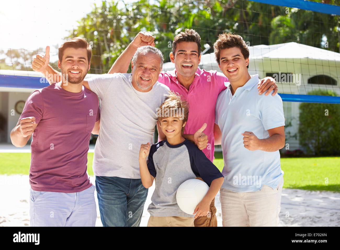 Male Multi Generation Family Playing Volleyball In Garden Stock Photo