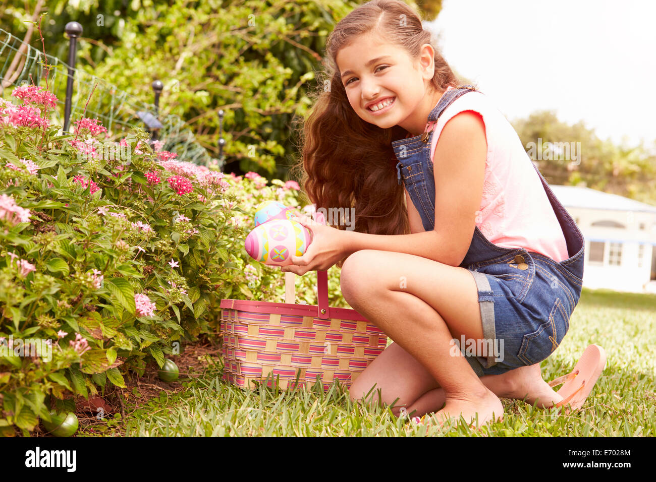 Girl Having Easter Egg Hunt In Garden Stock Photo
