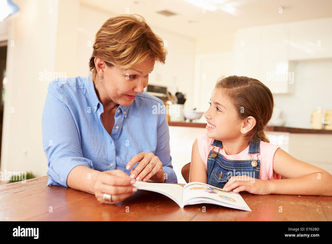 Grandmother Reading With Granddaughter At Home Stock Photo