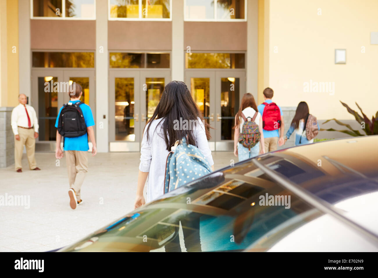 High School Students Being Dropped Off At School By Parents Stock Photo