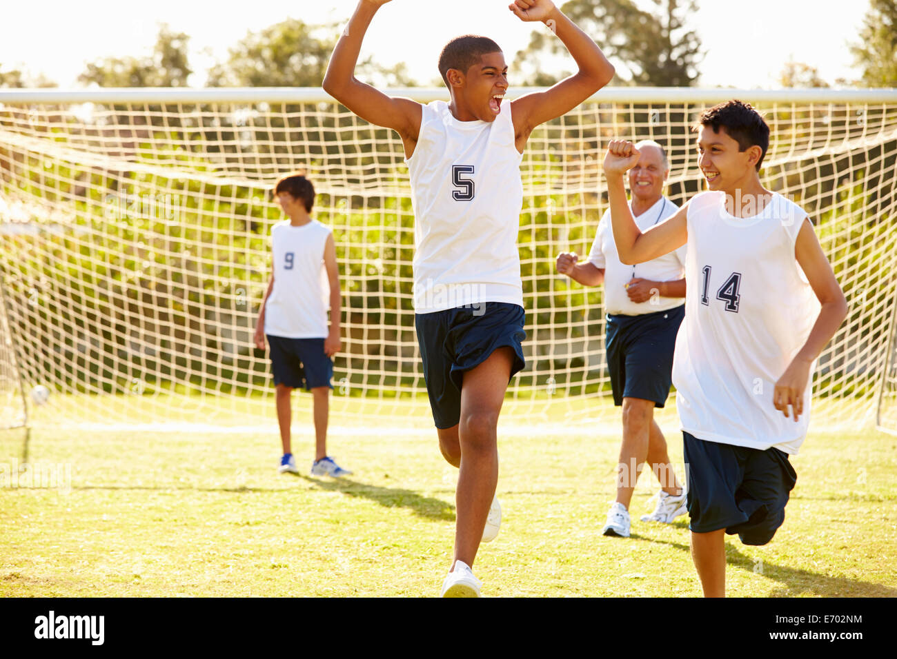 Player Scoring Goal In High School Soccer Match Stock Photo