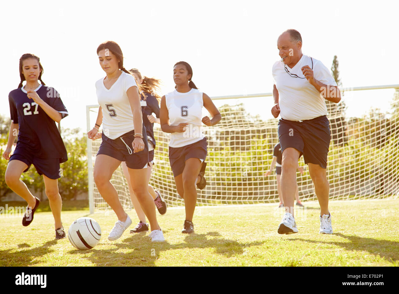 Members Of Female High School Soccer Playing Match Stock Photo