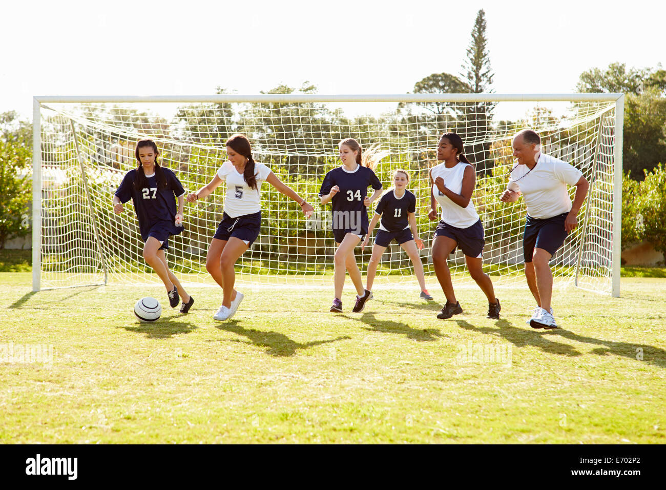 Members Of Female High School Soccer Playing Match Stock Photo
