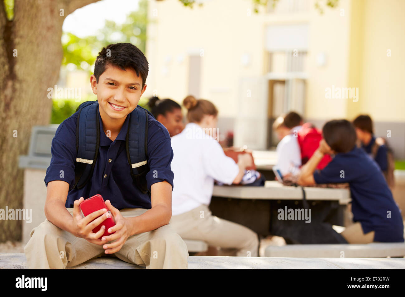 Male High School Student Using Phone On School Campus Stock Photo