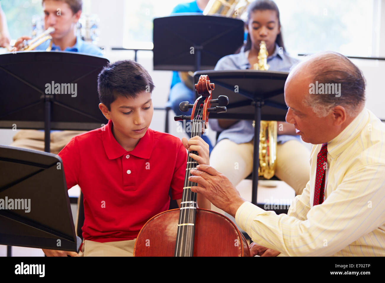 Boy Learning To Play Cello In High School Orchestra Stock Photo