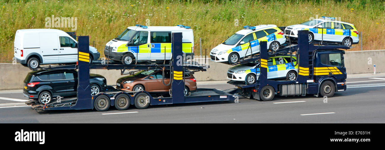Car transporter and trailer loaded with selection of vehicles including vehicles from the Wales police service Stock Photo