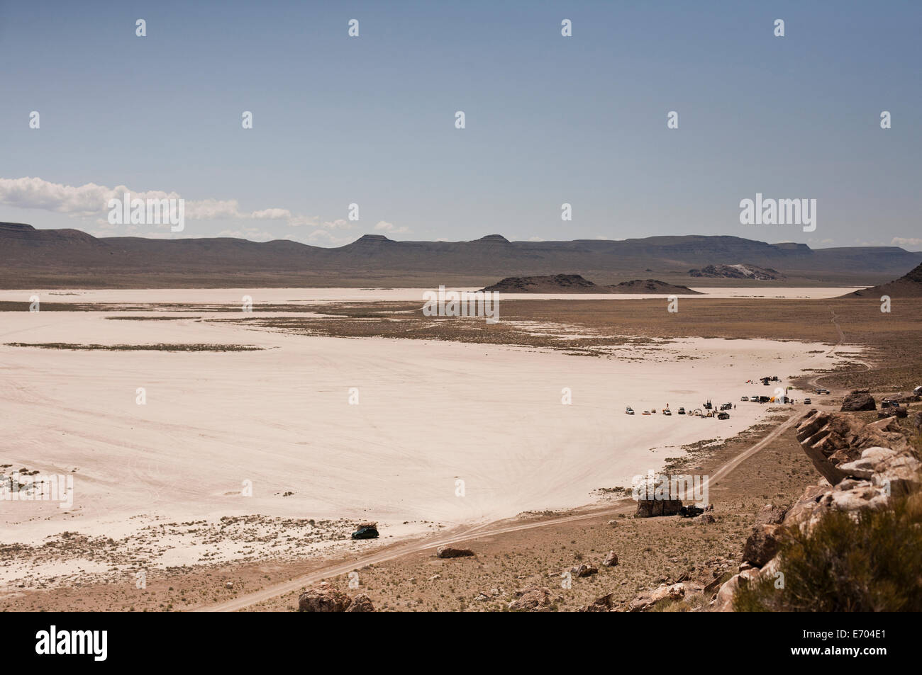 Salt flats with distant view of campers and off road vehicles, Ibex, Utah, USA Stock Photo