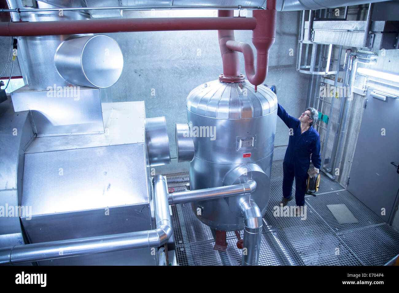 Elevated view of engineer inspecting machinery in power station Stock Photo