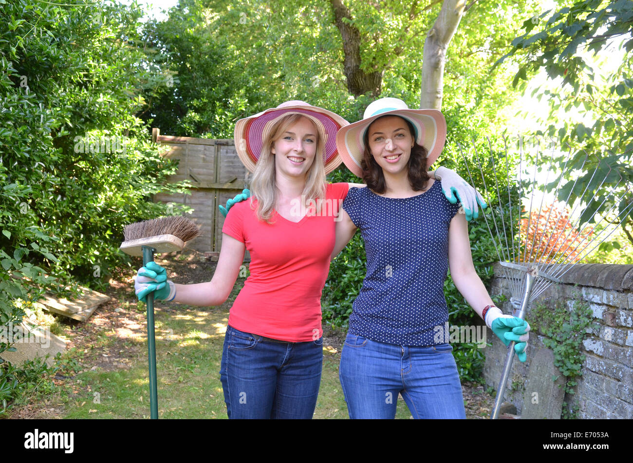 Portrait of young women holding gardening equipment Stock Photo