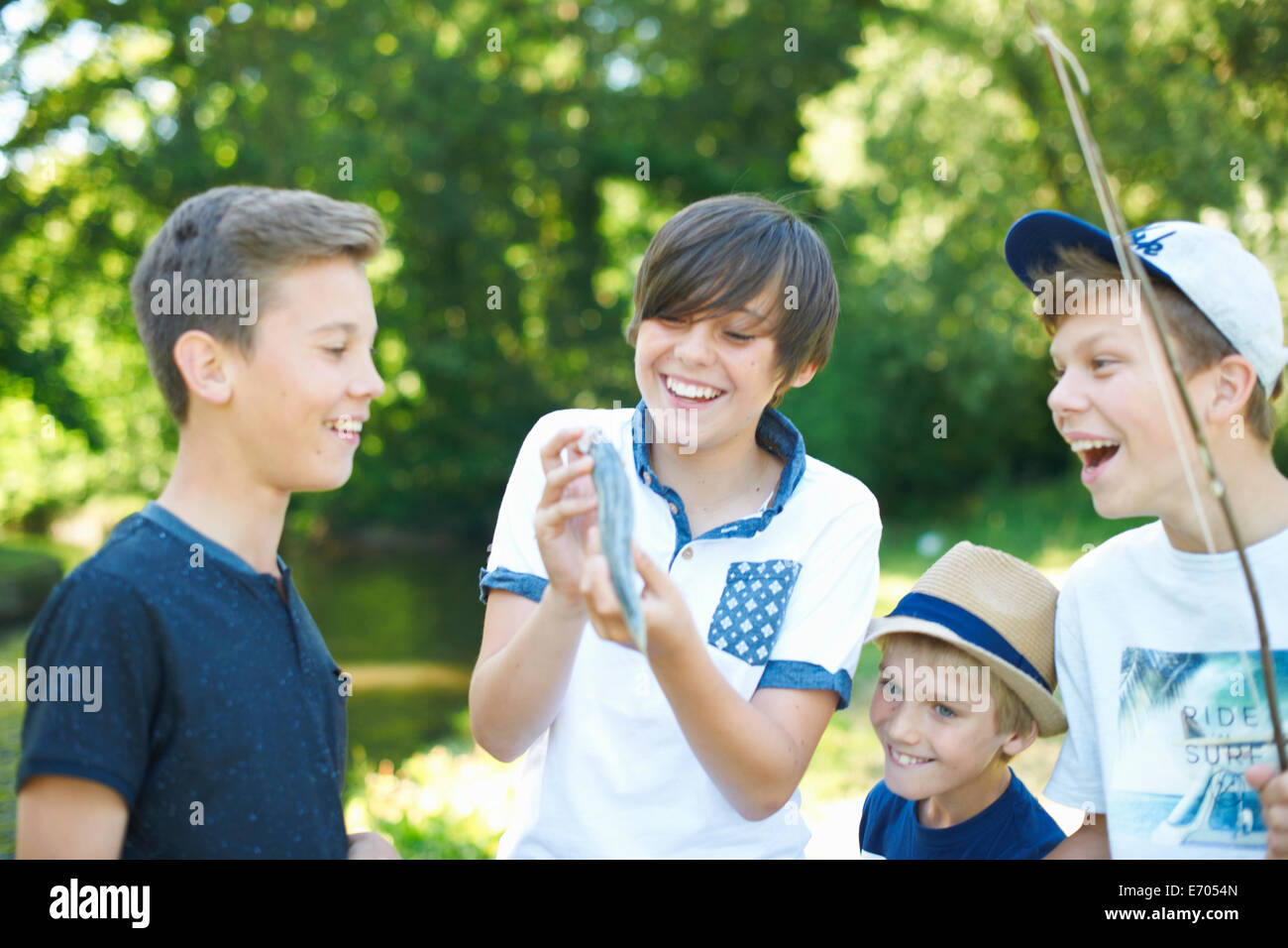 Boy holding fish with friends Stock Photo