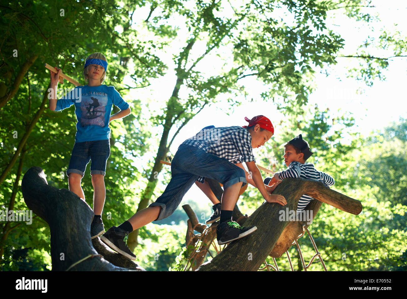 Young boys dressed as pirates, playing in tree Stock Photo