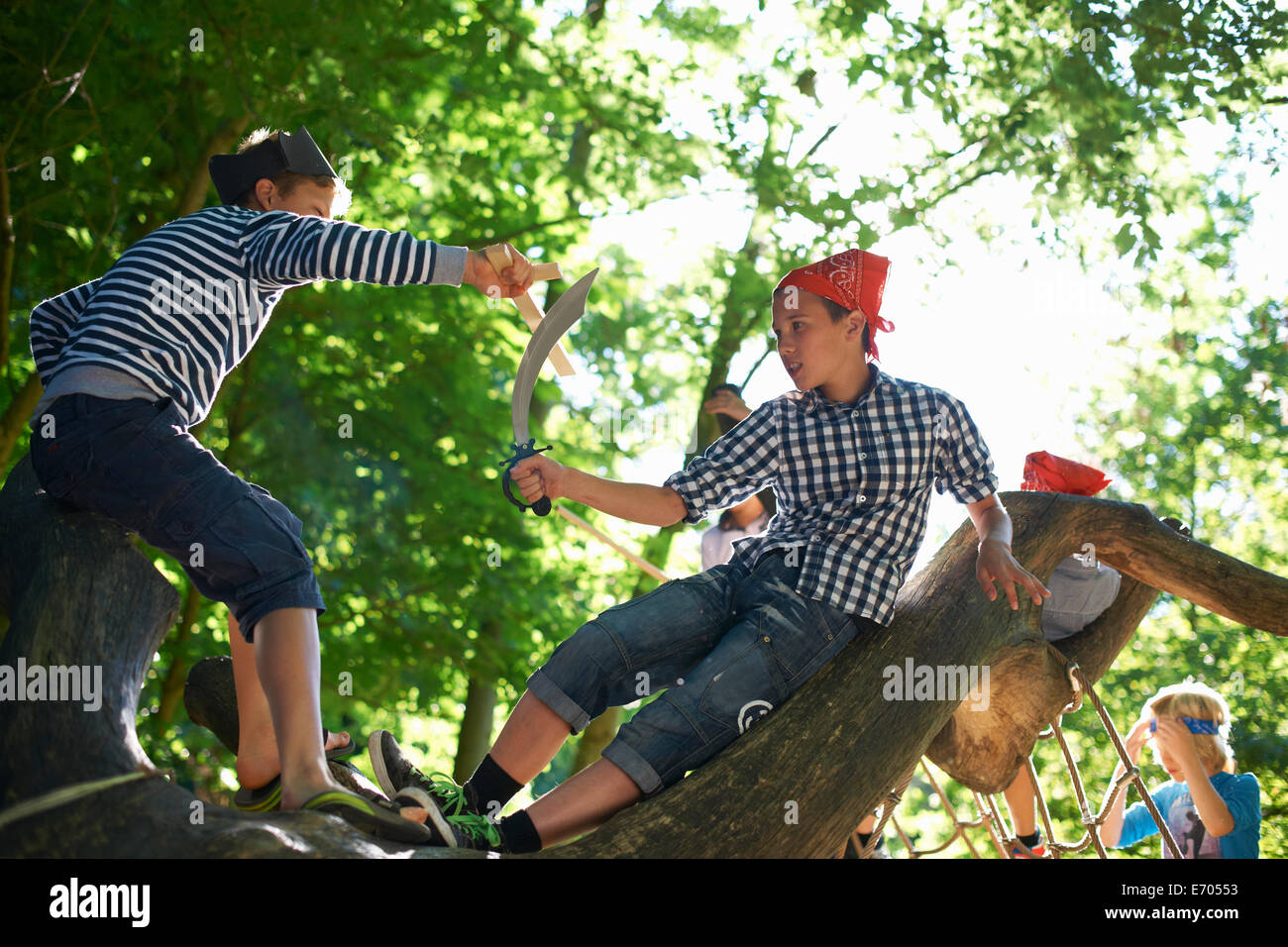 Young boys dressed as pirates, playing in tree Stock Photo