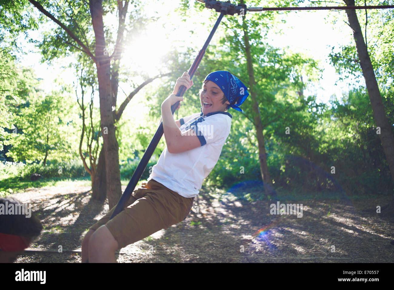 Young boy in fancy dress, on zip wire Stock Photo
