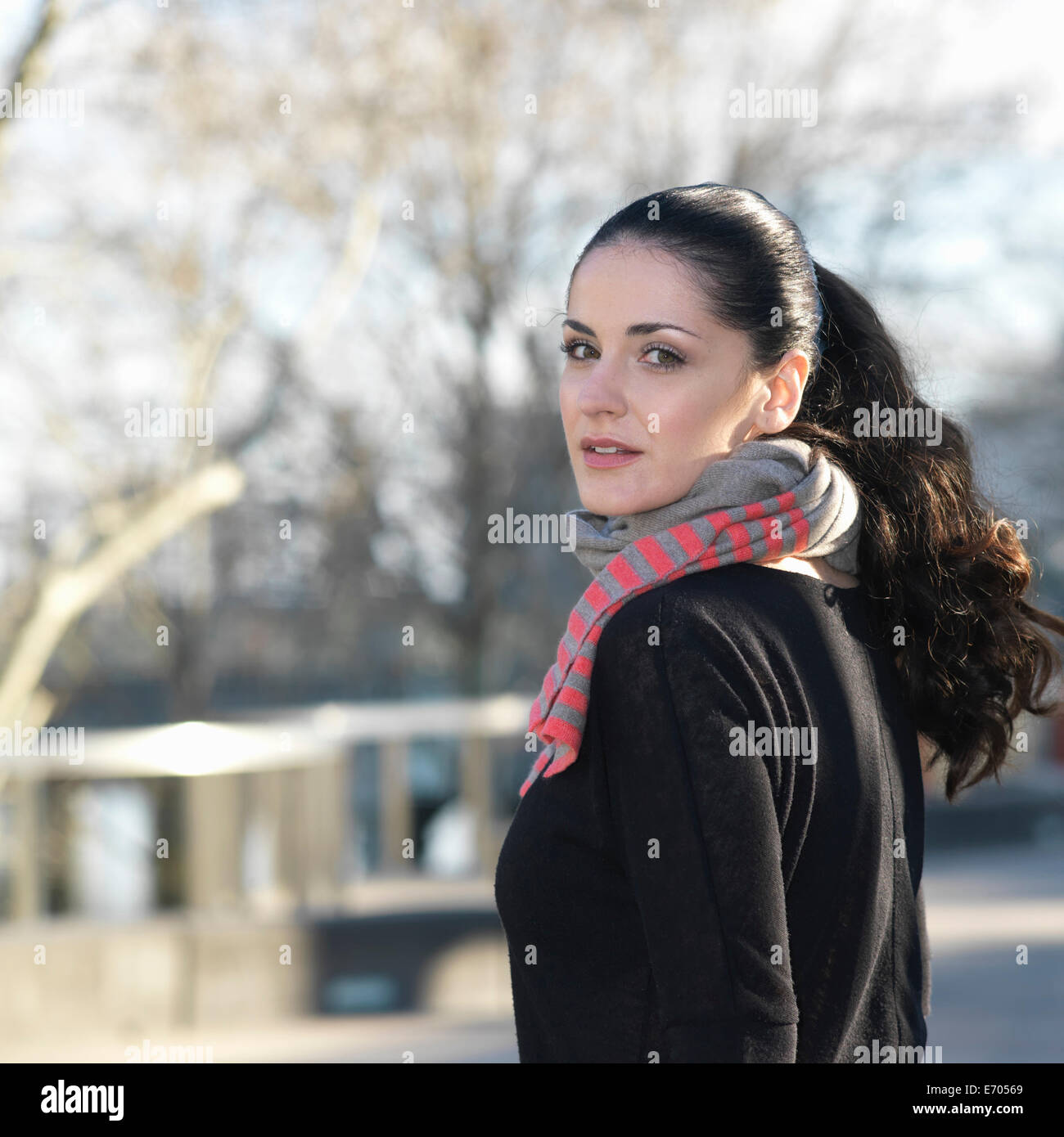 Portrait of young woman looking over her shoulder Stock Photo
