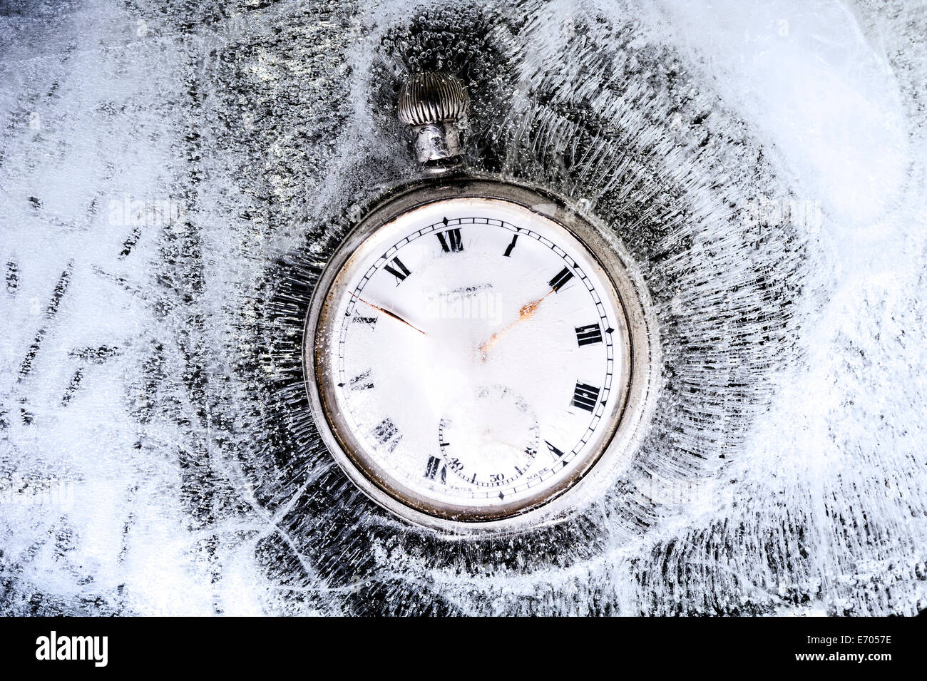 Pocket watch stuck in ice, frozen in time. Stock Photo