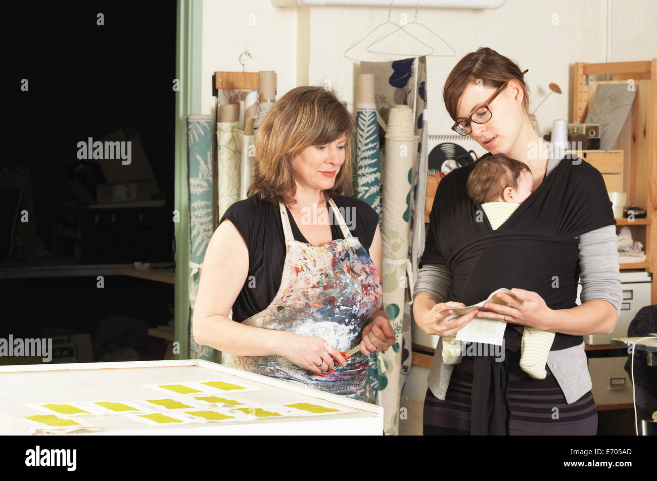 Women discussing design in hand-printing textile workshop Stock Photo