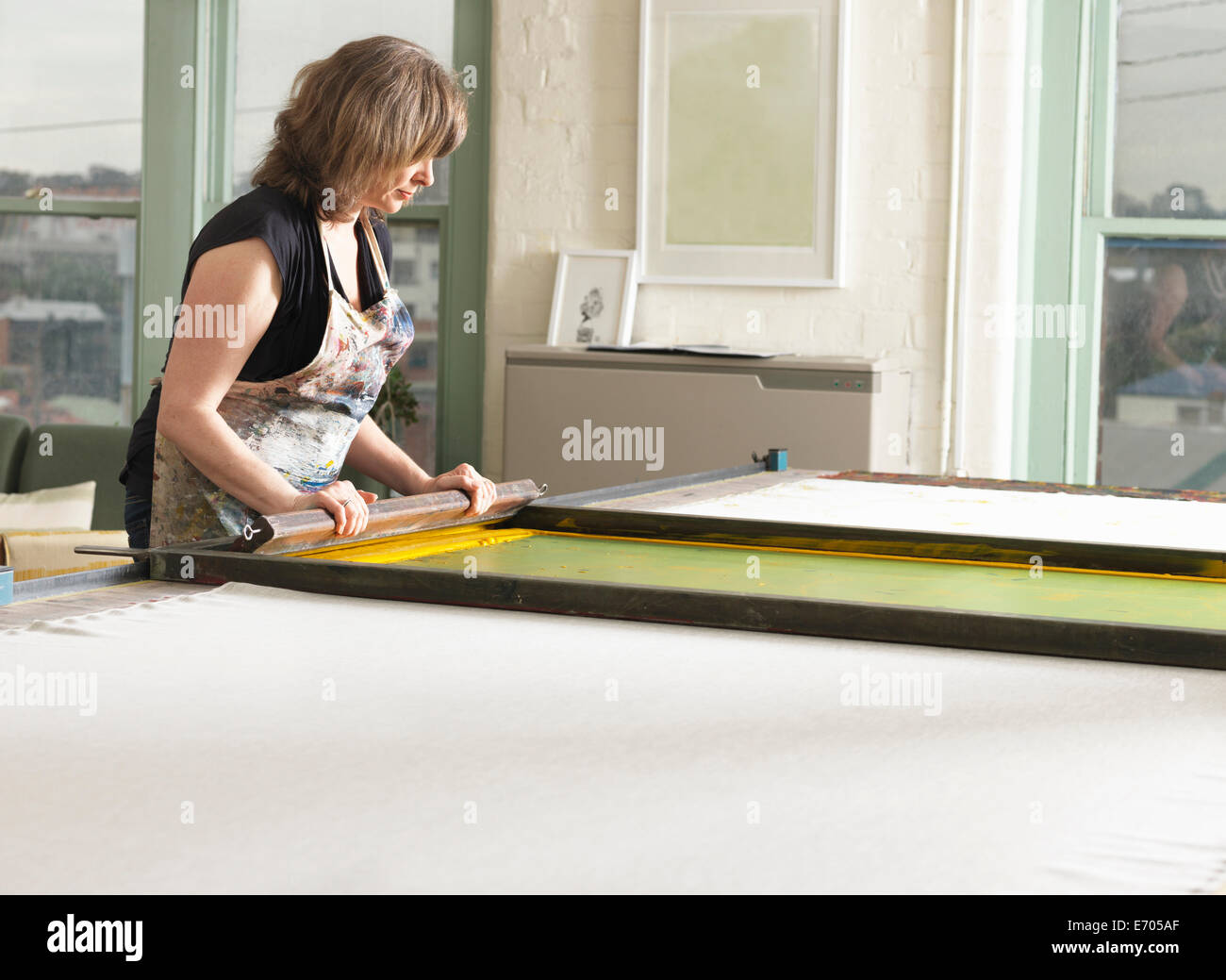 Woman hand-printing textile in workshop Stock Photo