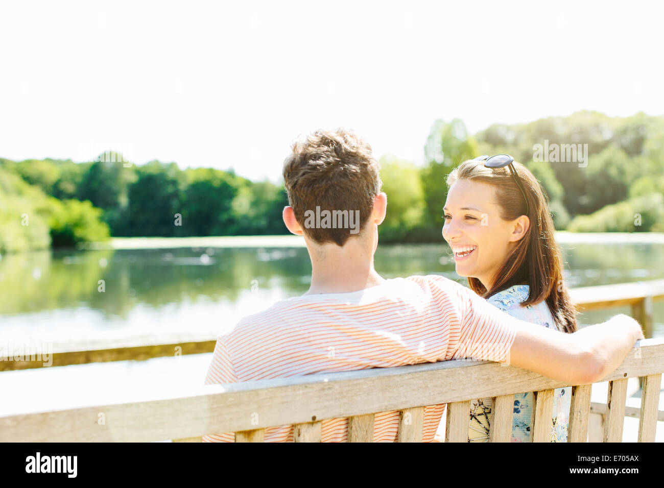 Couple sitting on wooden park bench Stock Photo - Alamy