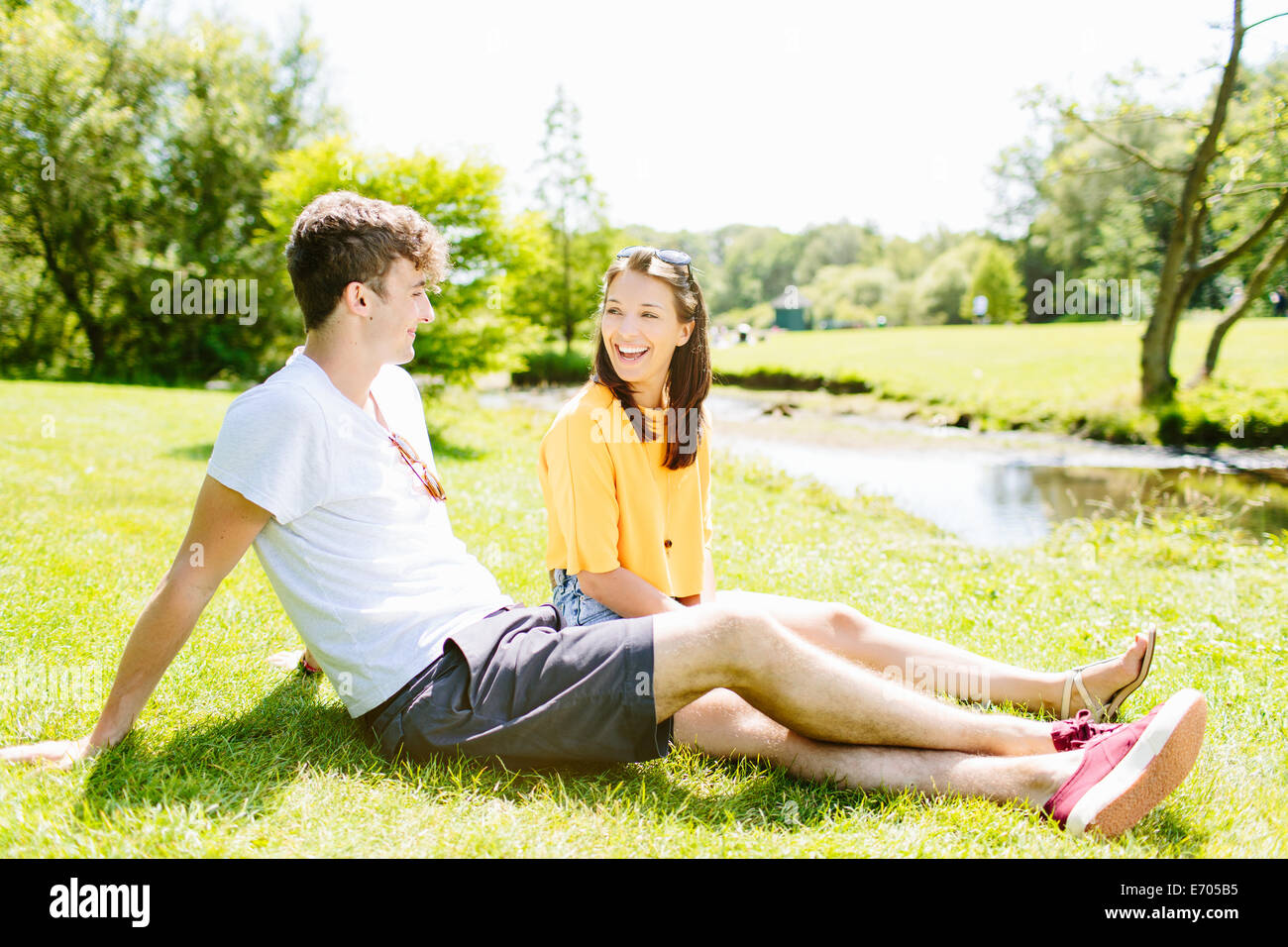 Couple sitting on grass in the park Stock Photo