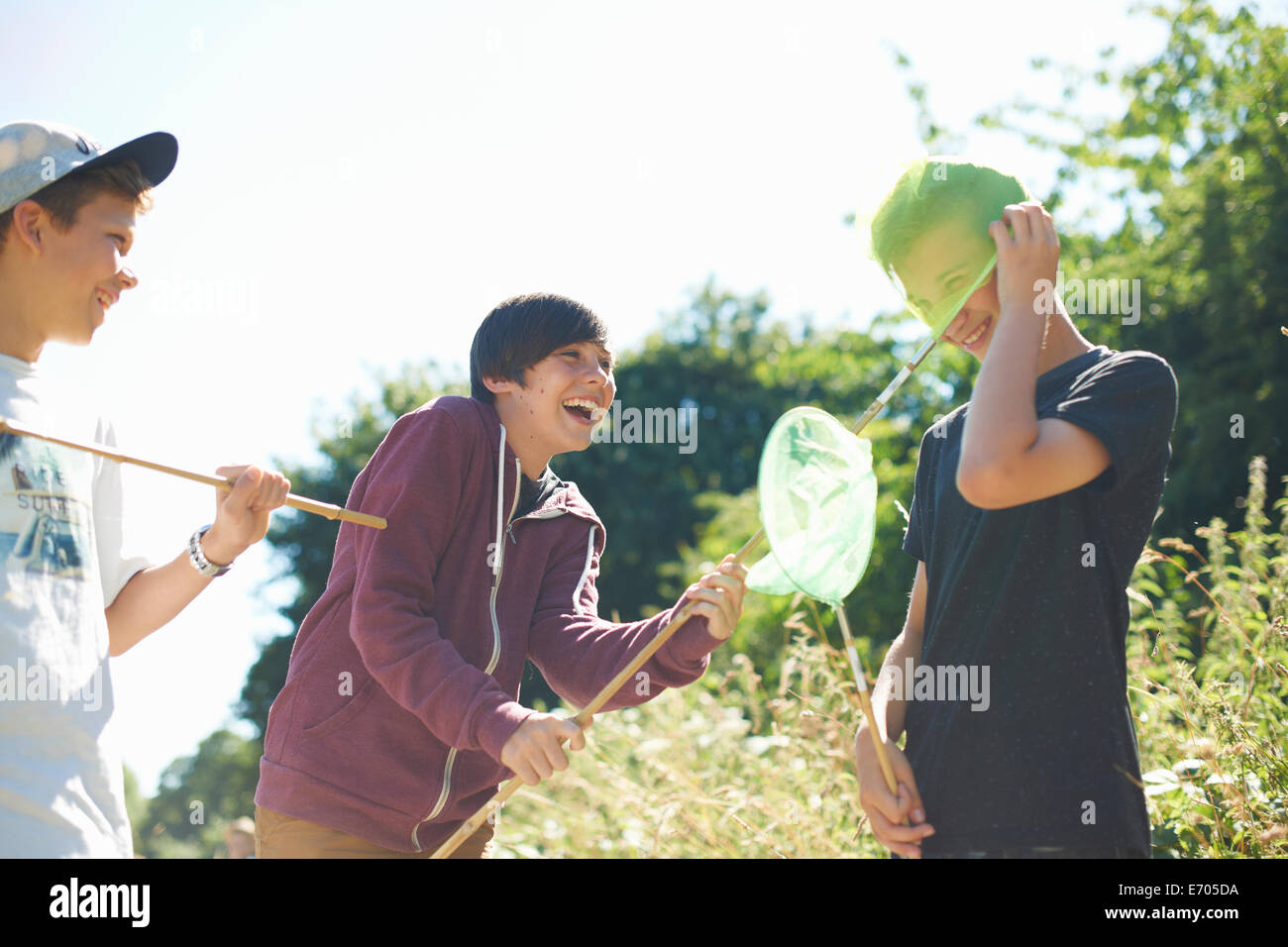 Three boys playing with fishing nets Stock Photo