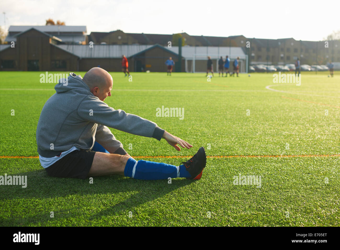 Football player stretching before game Stock Photo Alamy