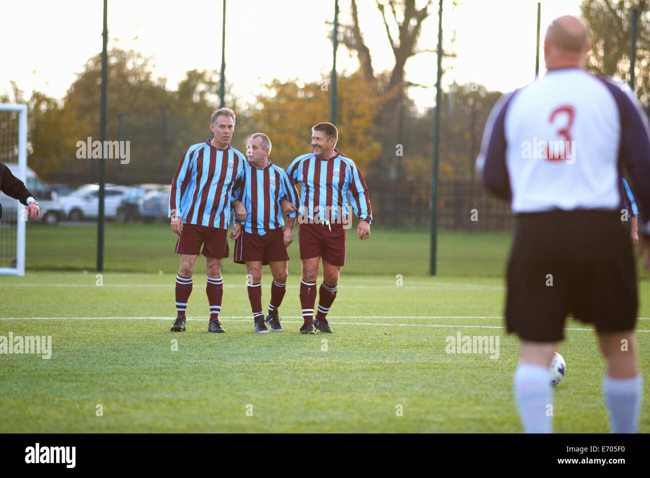 Football players forming wall to defend free kick Stock Photo