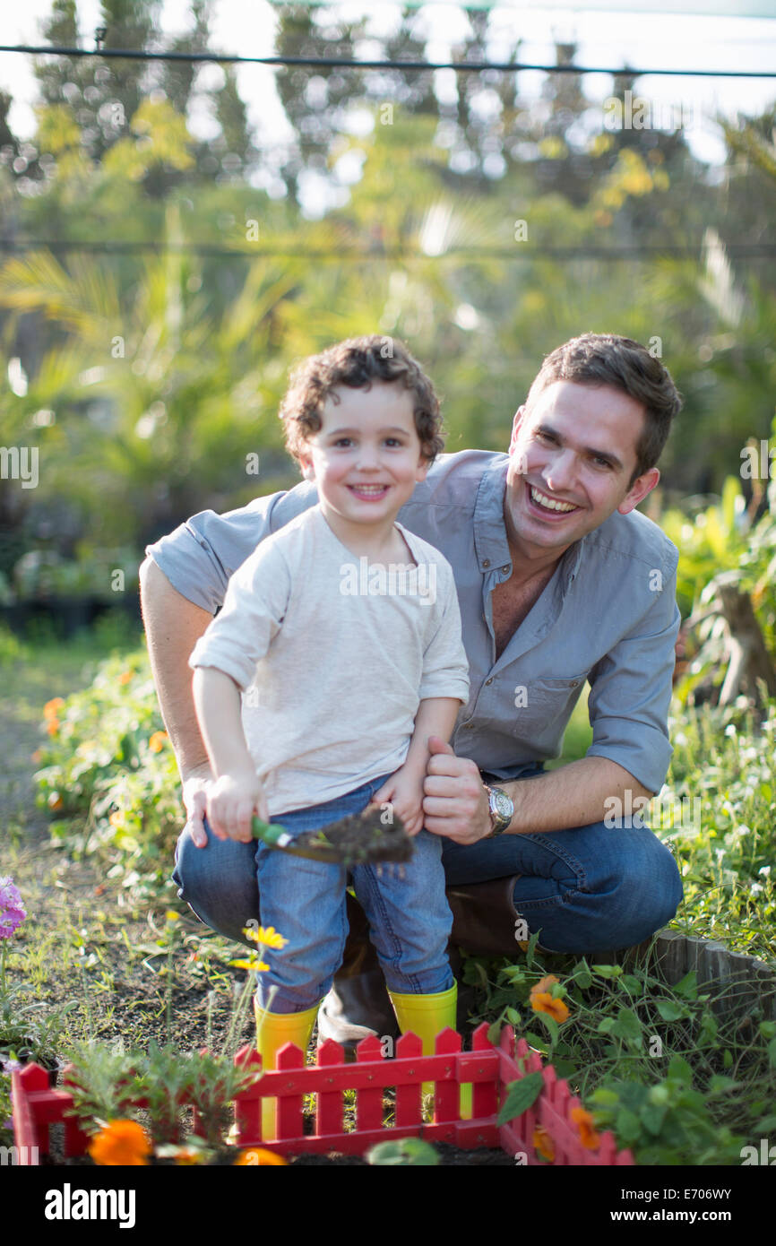 Portrait of mid adult man and son gardening in allotment Stock Photo