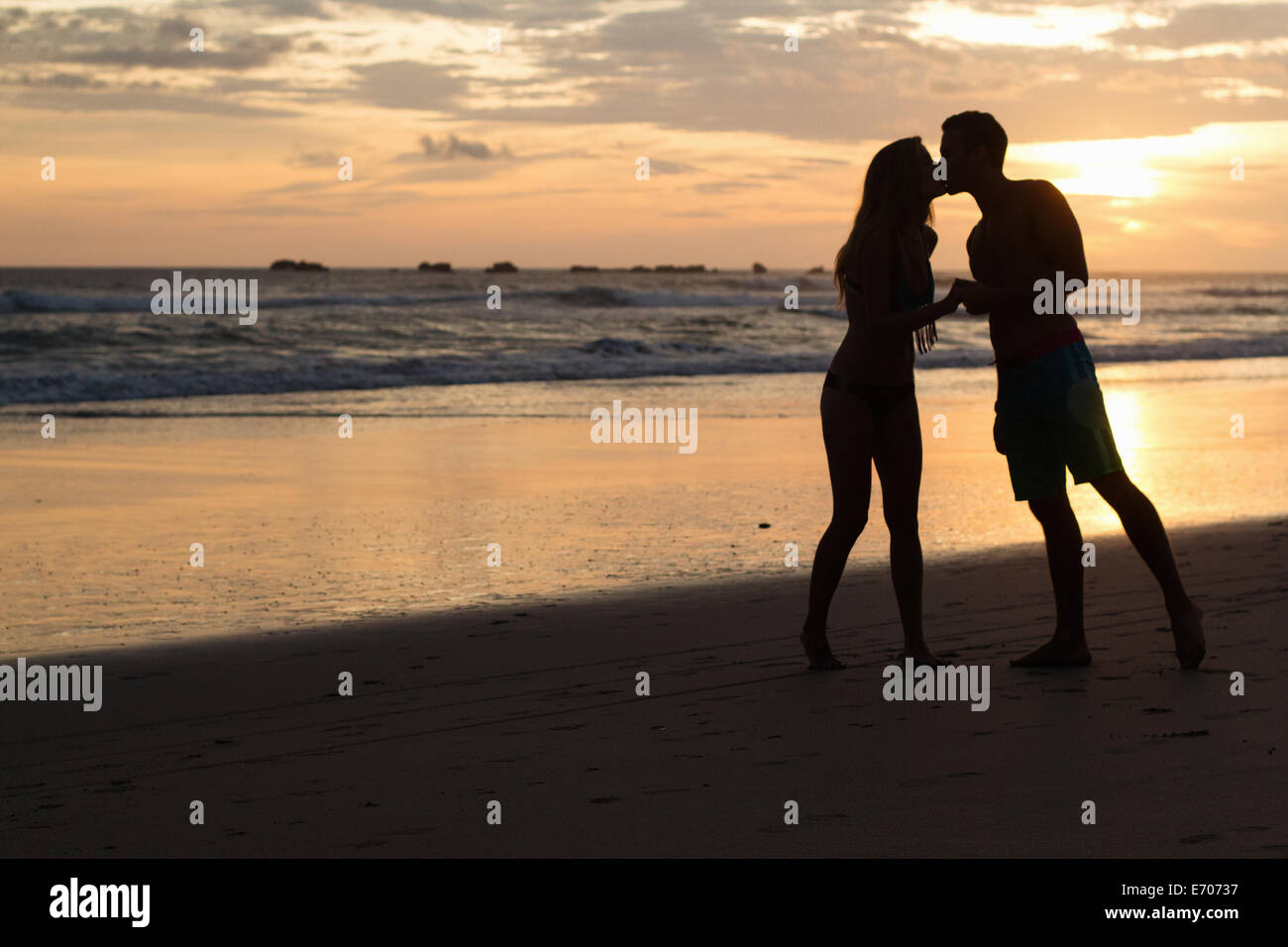 Silhouette of romantic couple kissing on beach, Nosara, Guanacaste, Costa Rica Stock Photo
