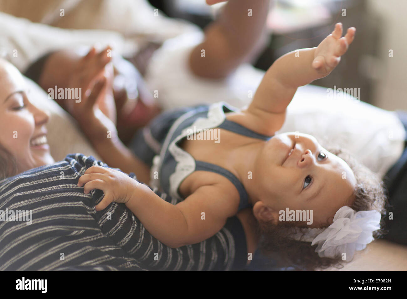 Mother and father lying on bed with baby daughter Stock Photo