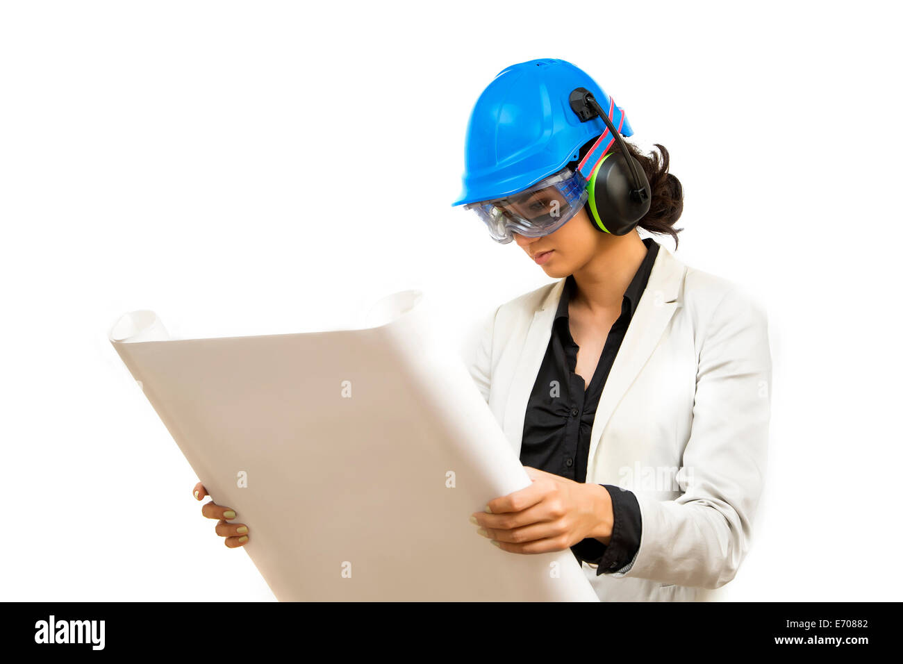 Young woman in protective workwear looking at blueprint Stock Photo - Alamy