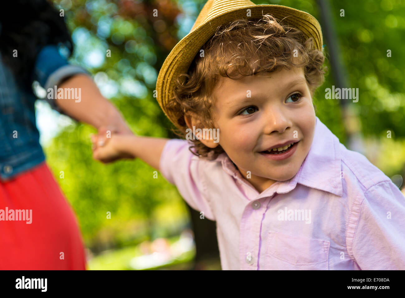 Close up of boy holding mother's hand in park Stock Photo