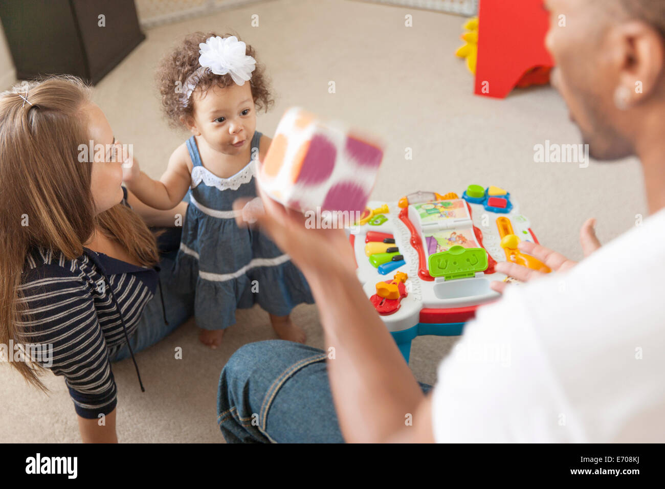 Mother and father playing with young daughter Stock Photo