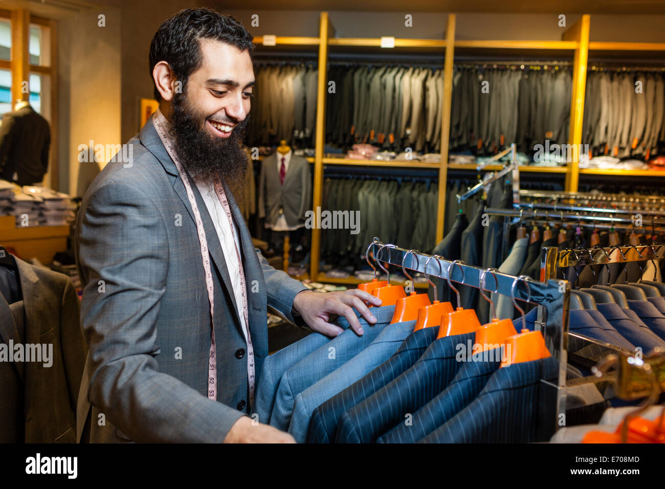 Tailor looking at business jacket display in men's clothes shop Stock Photo