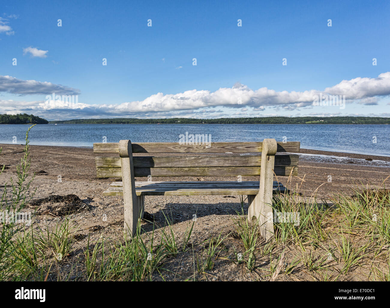 An old wood and concrete bench facing the Penobscot River at Sandy Point Beach in Stockton Springs Maine. Stock Photo