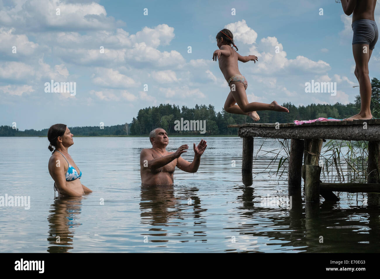 Family enjoying a swim, Zelwa Lake, Giby, Poland Stock Photo