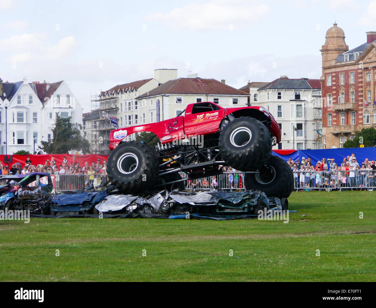 The monster truck 'lil' devil' rides over and crushes cars during the Extreme Stunt show in Portsmouth, Hampshire England Stock Photo