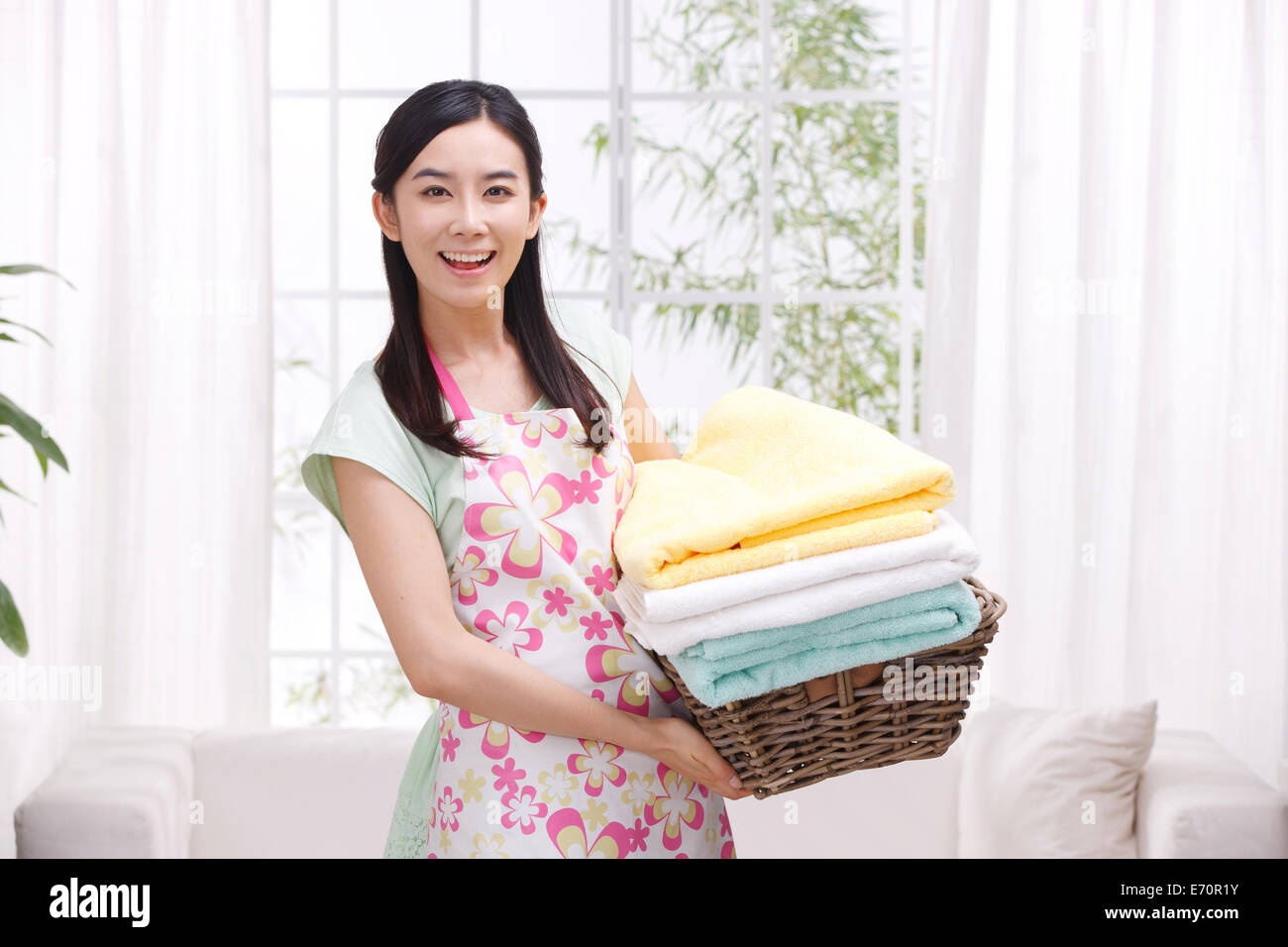 Young woman holding basket of towels Stock Photo - Alamy