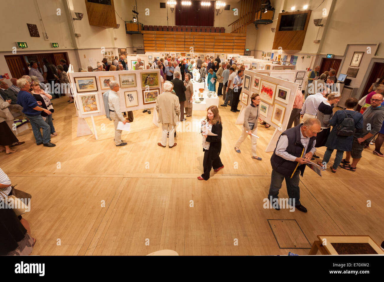Guests crowd the exhibition hall to view the exhibits at the Petersfield Arts and Crafts 2014 Exhibition preview evening. Stock Photo